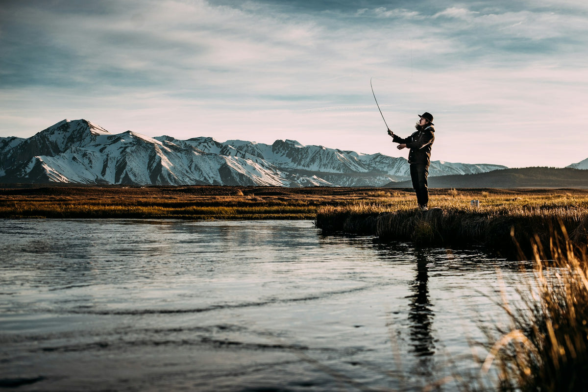 Angler fly fishing on the Deschutes River with canyon walls in the background