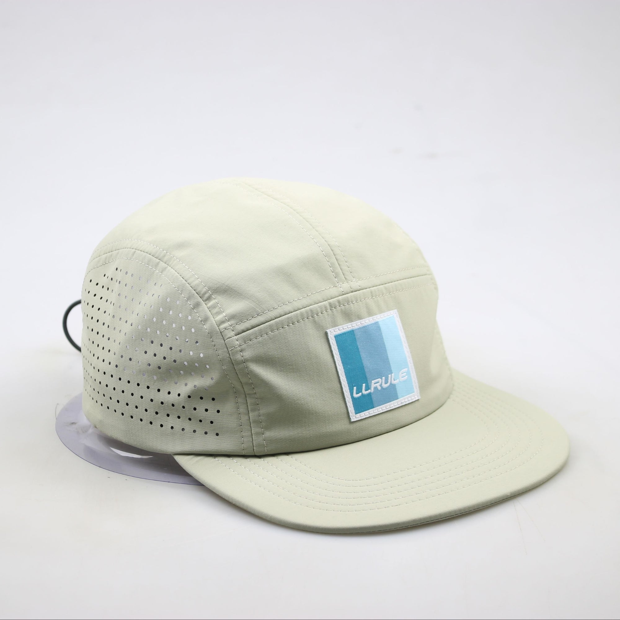 Side view of Ridgeflow pull cap in sandstone showing sleek profile and logo