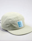 Side view of Ridgeflow pull cap in sandstone showing sleek profile and logo