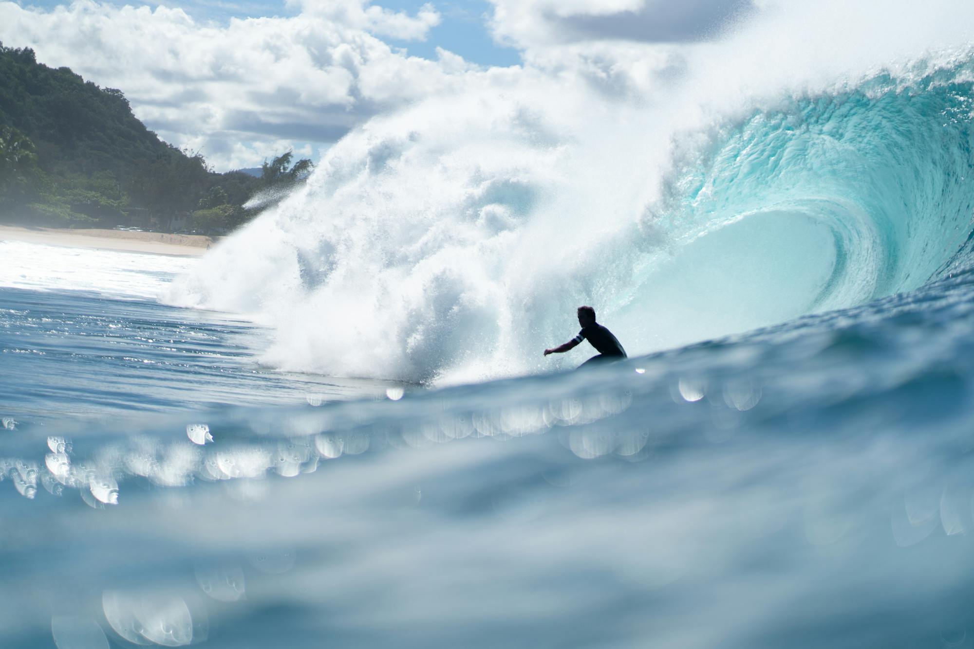 THE LINEUP — Silhouette of a surfer tackling a giant ocean wave